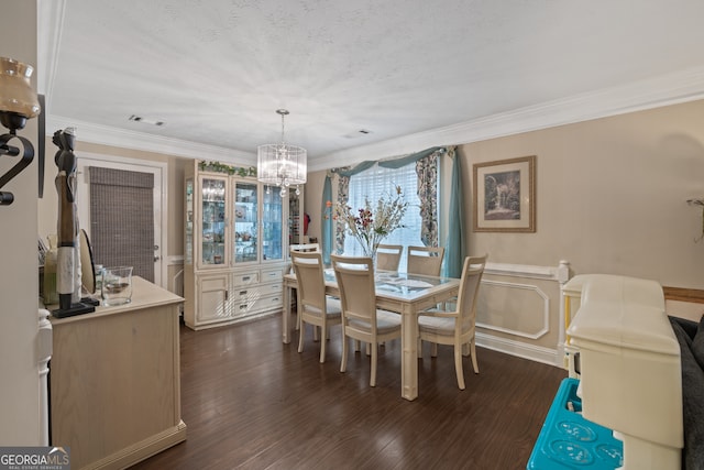 dining space with an inviting chandelier, dark hardwood / wood-style floors, ornamental molding, and a textured ceiling