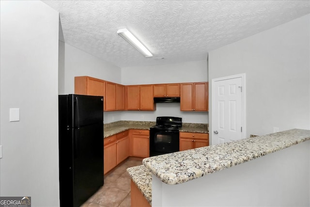 kitchen with black appliances, kitchen peninsula, light stone counters, and a textured ceiling