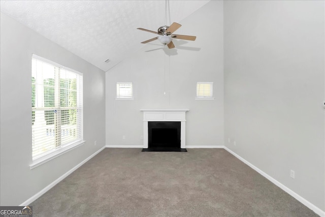 unfurnished living room with ceiling fan, light colored carpet, a textured ceiling, and a healthy amount of sunlight