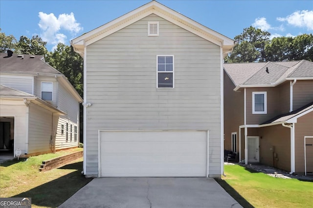 exterior space with a garage and a lawn