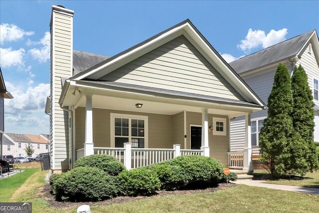 view of front of home with a front yard and a porch