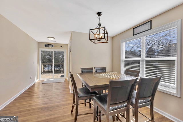 dining room with a notable chandelier and light wood-type flooring