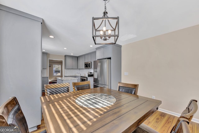 dining space featuring a notable chandelier and light hardwood / wood-style flooring