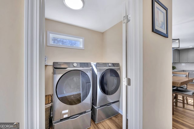 laundry area featuring light wood-type flooring and separate washer and dryer