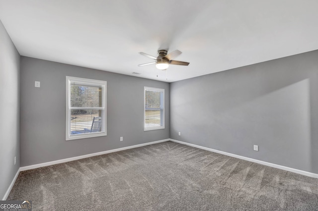 carpeted spare room featuring ceiling fan