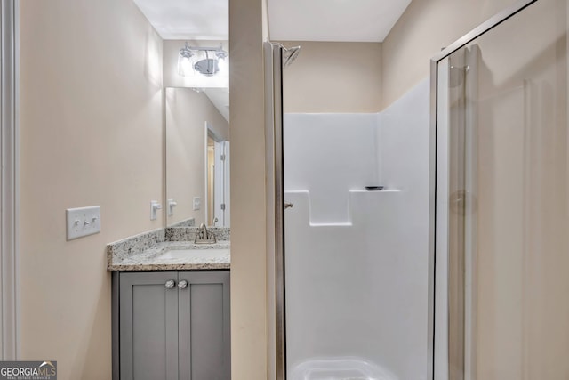 bathroom featuring vanity and a shower with shower door