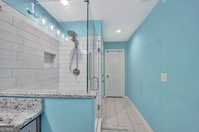 bathroom featuring walk in shower and vanity