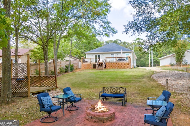 view of yard featuring a wooden deck, a patio area, and a fire pit