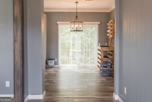 unfurnished dining area with an inviting chandelier and dark hardwood / wood-style flooring