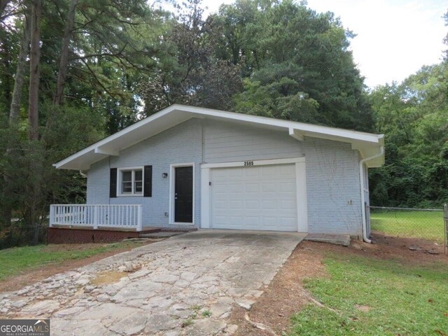 ranch-style house featuring a garage and a front lawn