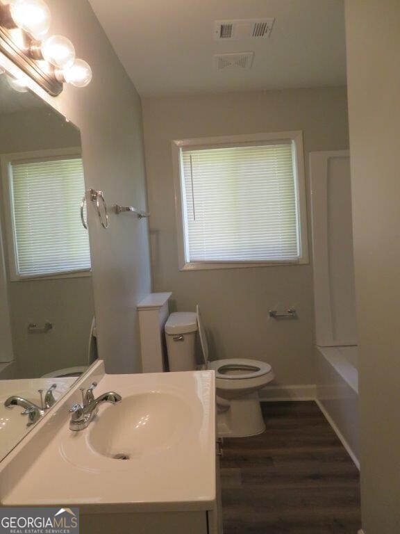 bathroom featuring hardwood / wood-style floors, vanity, and toilet