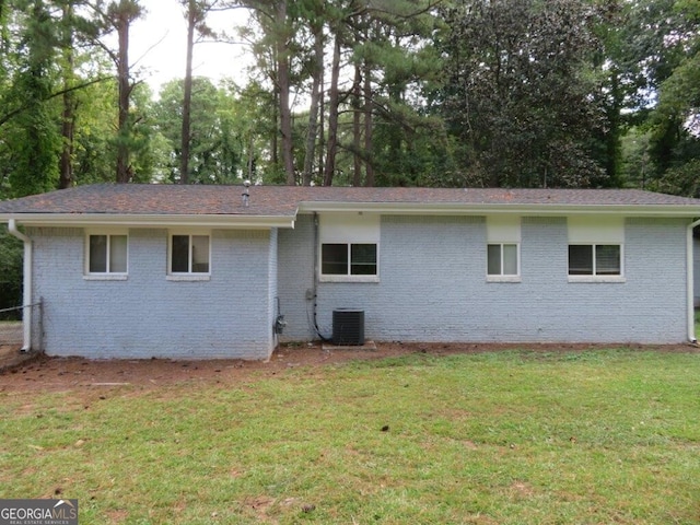 rear view of house with a lawn and central air condition unit