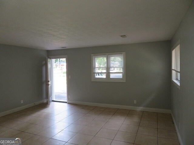 tiled spare room featuring a wealth of natural light