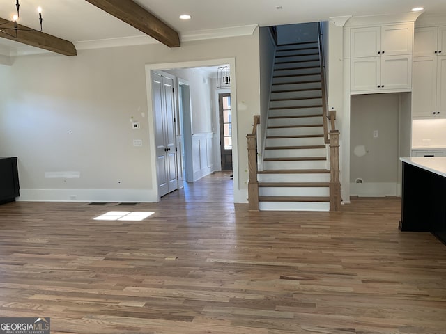 interior space featuring beamed ceiling, hardwood / wood-style floors, and crown molding