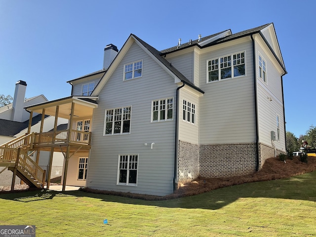 back of property featuring a lawn, ceiling fan, and a deck