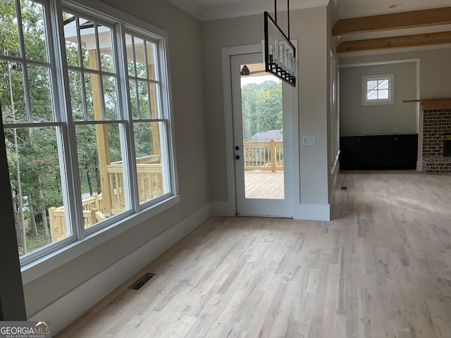 doorway with wood-type flooring and a brick fireplace