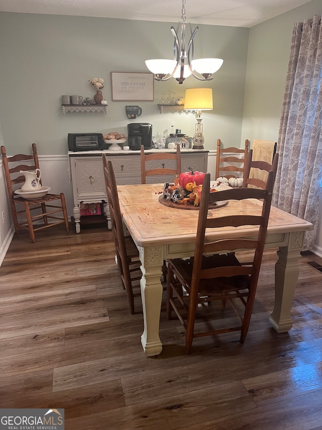 dining room featuring a notable chandelier, a textured ceiling, and dark hardwood / wood-style flooring