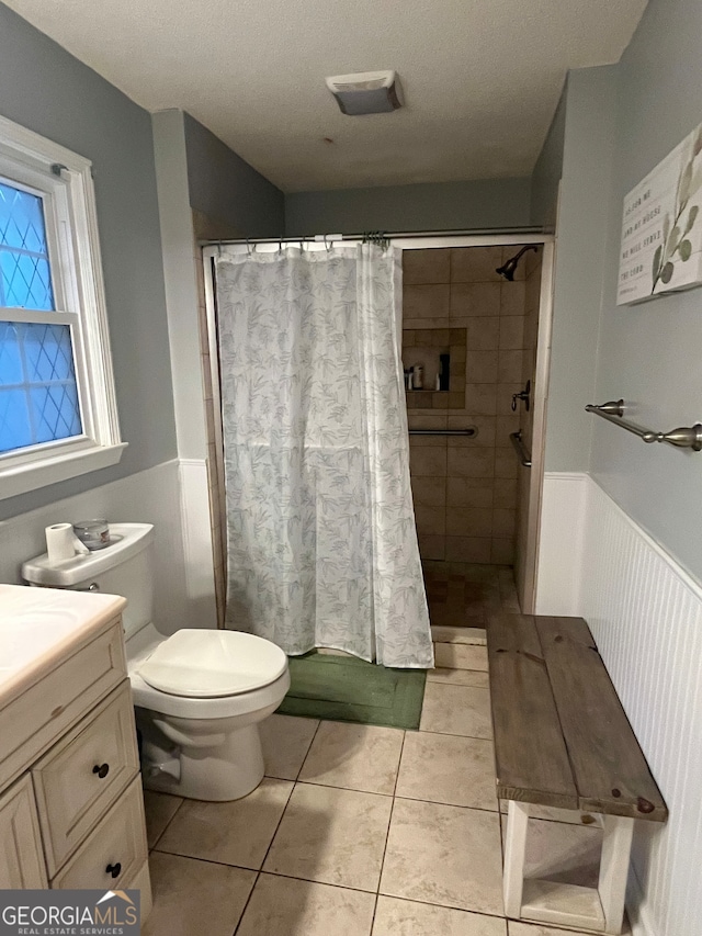 bathroom featuring curtained shower, vanity, a textured ceiling, toilet, and tile patterned floors