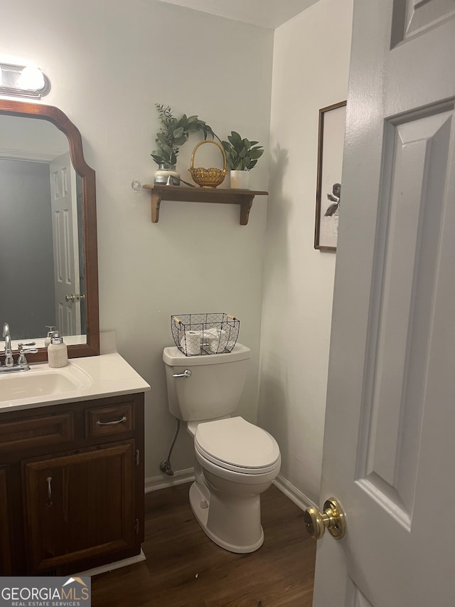 bathroom with vanity, toilet, and hardwood / wood-style flooring