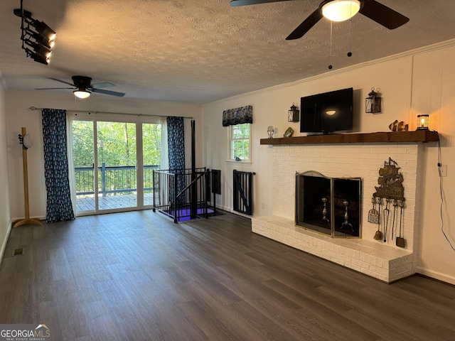 unfurnished living room featuring dark wood-type flooring, ceiling fan, a fireplace, and a textured ceiling