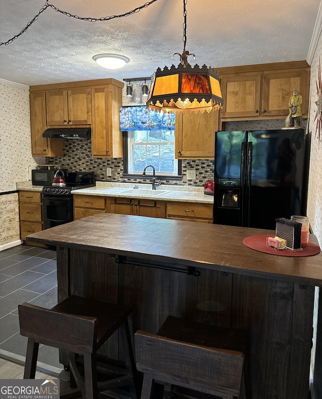 kitchen with a textured ceiling, black appliances, sink, backsplash, and hanging light fixtures