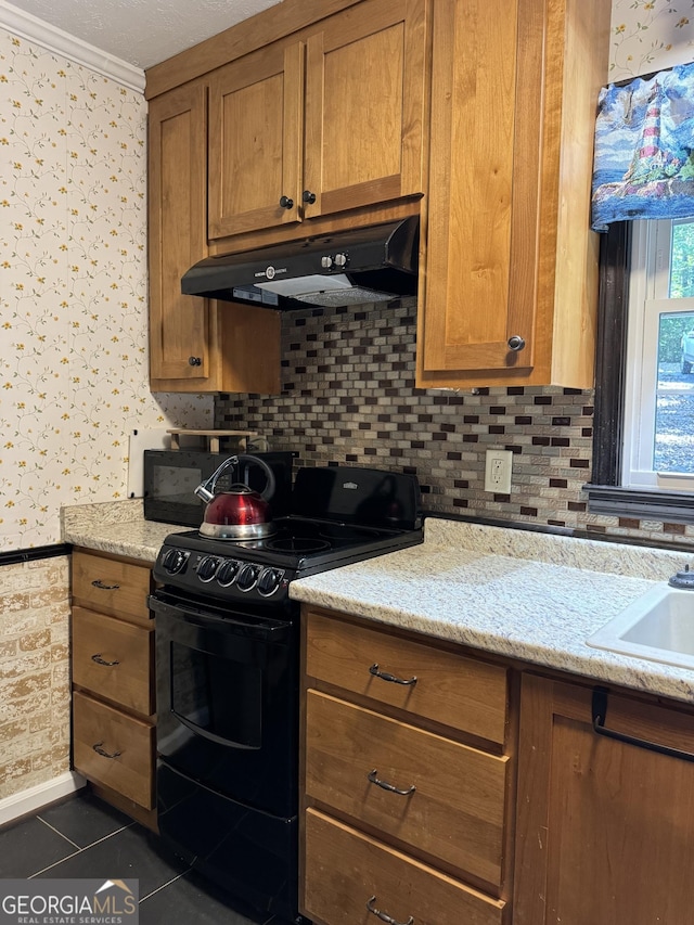 kitchen with ornamental molding, black range oven, dark tile patterned flooring, and light stone counters