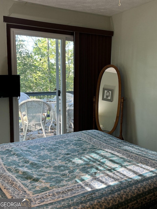 bedroom featuring access to exterior and a textured ceiling