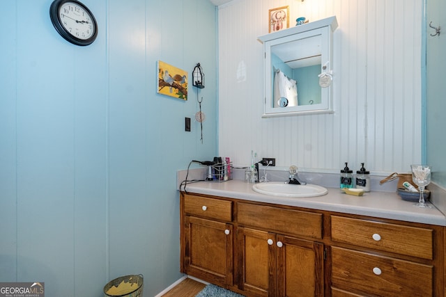 bathroom with wood walls and vanity