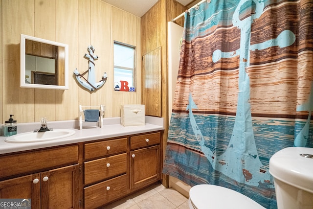 bathroom with a shower with curtain, vanity, wooden walls, toilet, and tile patterned floors