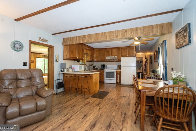 kitchen with light hardwood / wood-style floors, heating unit, white appliances, kitchen peninsula, and ceiling fan