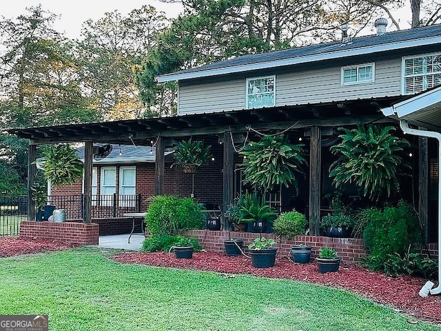 rear view of property with a yard and a pergola