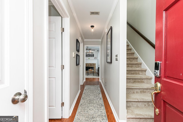 corridor with hardwood / wood-style floors and crown molding