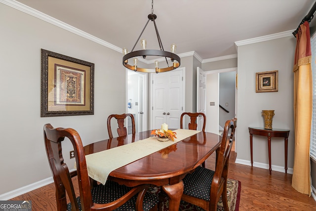 dining room with dark hardwood / wood-style flooring, crown molding, and an inviting chandelier