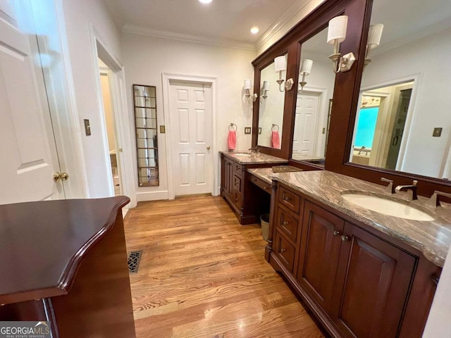 bathroom featuring crown molding, vanity, and wood-type flooring