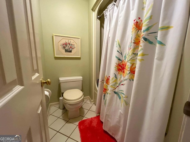 bathroom with tile patterned floors, curtained shower, and toilet