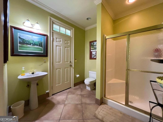 bathroom featuring tile patterned floors, a shower with shower door, toilet, and ornamental molding