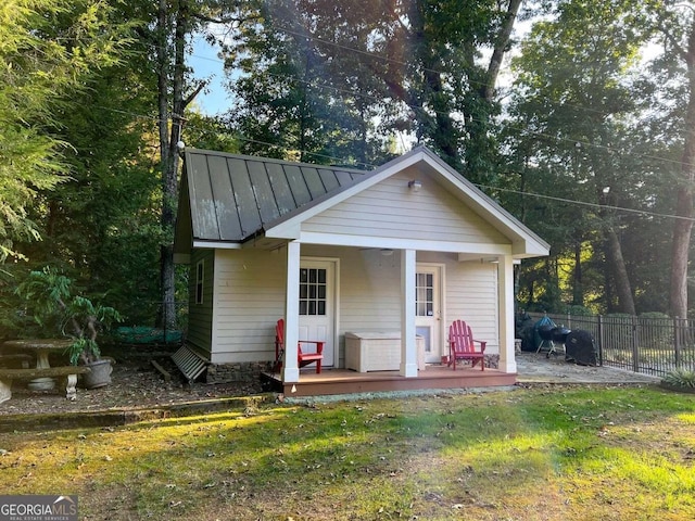 view of outbuilding featuring a porch and a yard