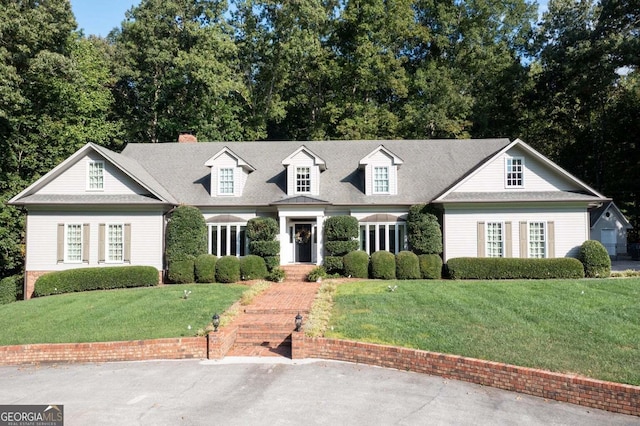 cape cod-style house with a front yard