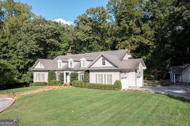 cape cod house featuring a front lawn and a garage