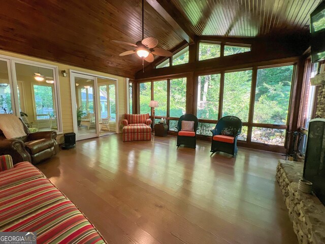 sunroom with vaulted ceiling with beams, ceiling fan, and wood ceiling