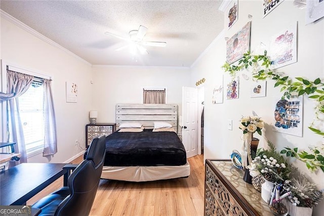 bedroom with light wood-type flooring, a textured ceiling, ornamental molding, and ceiling fan