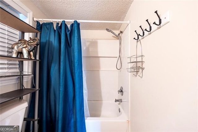 bathroom with shower / tub combo with curtain, a textured ceiling, and toilet