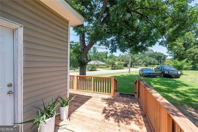 wooden terrace featuring a yard