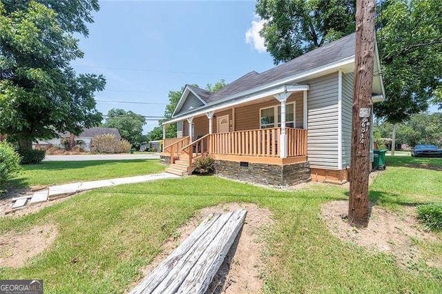 rear view of house featuring covered porch and a yard