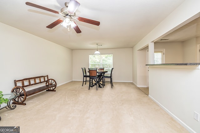 carpeted dining room featuring ceiling fan