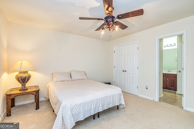 carpeted bedroom featuring a closet, ceiling fan, and ensuite bathroom