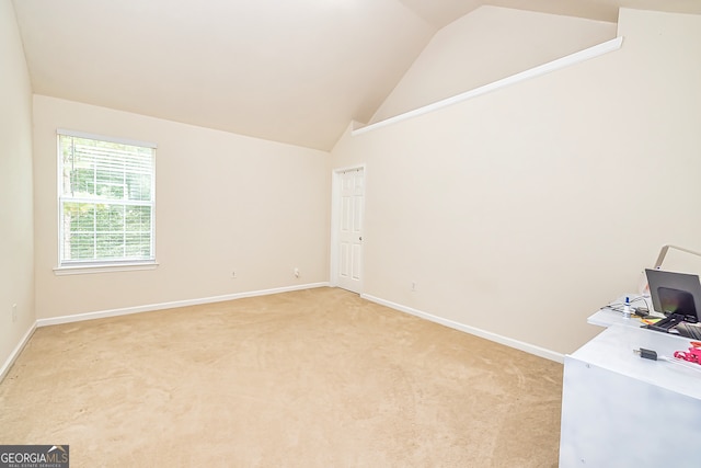 carpeted office featuring lofted ceiling