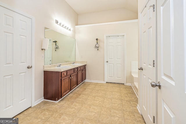 bathroom with tile patterned floors, a tub, and vanity