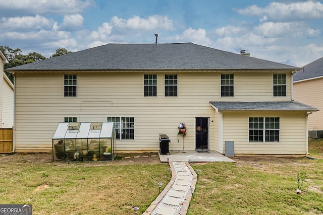 rear view of property featuring a lawn, central air condition unit, and a patio area