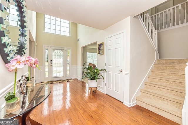 foyer featuring a towering ceiling and hardwood / wood-style floors